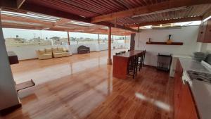 eine Küche und ein Wohnzimmer mit Holzboden in der Unterkunft hospedaje sol y mar in Pisco