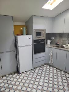 een keuken met een koelkast en een magnetron bij Apartamento Estoril in Estoril