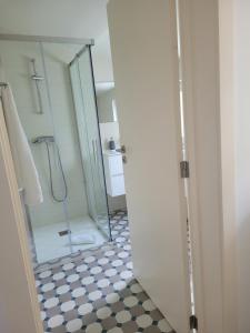 a bathroom with a shower and a glass door at Apartamento Estoril in Estoril