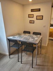 une table avec quatre chaises dans une pièce dans l'établissement Apartamento Estoril, à Estoril