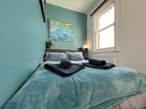a bedroom with a bed with towels on it at Seaside Apartment close to beach, town, station in Broadstairs
