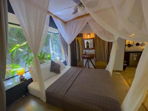 um quarto com uma cama de dossel e uma janela em Canaima Chill House em Santa Teresa