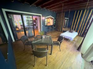 um quarto com uma mesa e cadeiras e uma cama em Canaima Chill House em Santa Teresa