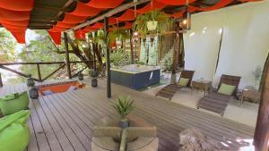 e terrazza all'aperto con vasca idromassaggio e sedie. di Canaima Chill House a Santa Teresa Beach