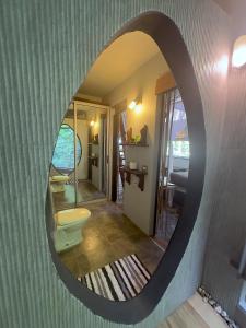 a mirror in a bathroom with a toilet in it at Canaima Chill House in Santa Teresa Beach