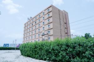 a tall building with a bush in front of it at OAKTREE HOTEL in Morbi