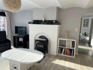 a living room with a fireplace and a table at Villa Louise in Stavelot