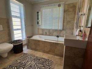 a bathroom with a tub and a toilet and a sink at Lieben Gast in De Kelders