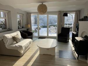 een woonkamer met een witte bank en een tafel bij Villa Louise in Stavelot