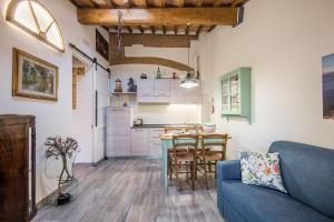 sala de estar con sofá azul y cocina en Lo Ziro - Agriturismo La Roverella, en Monteroni dʼArbia