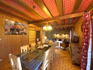 LE TRAPPEUR Chalet en bois في لابريس: غرفة طعام مع طاولة وكراسي خشبية كبيرة