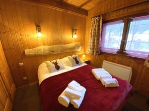 LE TRAPPEUR Chalet en bois في لابريس: غرفة نوم عليها سرير وفوط