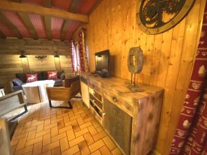 a room with a wooden wall with a tv in it at LE TRAPPEUR Chalet en bois in La Bresse