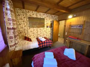 a bedroom with two beds and a desk in it at LE TRAPPEUR Chalet en bois in La Bresse