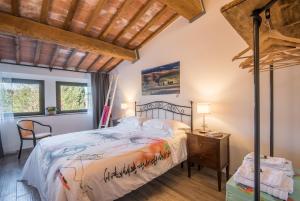 1 dormitorio con 1 cama y suelo de madera en Lo Ziro - Agriturismo La Roverella, en Monteroni dʼArbia