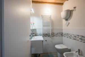 Baño blanco con aseo y lavamanos en Lo Ziro - Agriturismo La Roverella, en Monteroni dʼArbia