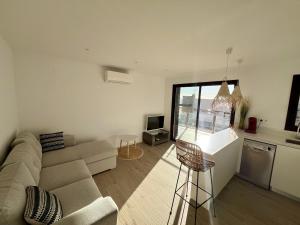 sala de estar blanca con sofá y cocina en IBR - Rhodes 23 en Rosas