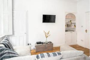 a living room with a couch and a tv at Orchard Street: 1BR with Garden in Bath