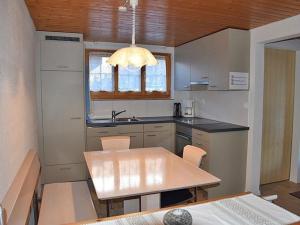 eine Küche mit einem Tisch und Stühlen sowie einem Fenster in der Unterkunft Ferienwohnung Steinideen in Meiringen