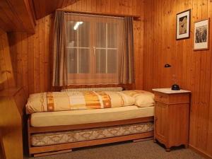 Bett in einem Zimmer mit einem Fenster und einem Tisch in der Unterkunft Ferienwohnung Steinideen in Meiringen