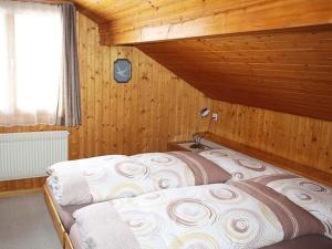 1 Schlafzimmer mit 2 Betten in einem Holzzimmer in der Unterkunft Ferienwohnung Steinideen in Meiringen