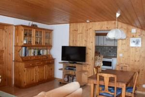 a living room with a table and a television at Chalet Huber 6-Bettwohnung in Meiringen