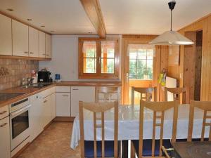 a kitchen with a table and chairs in a room at Chalet Huber 6-Bettwohnung in Meiringen