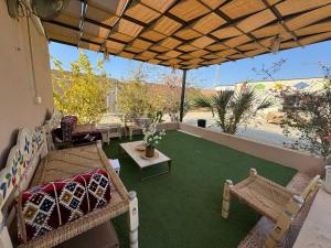 a patio with a couch and a table and chairs at شاليه مجهز بالكامل مسبح وملعب و حديقه هادئه بضباء in Ḑubā
