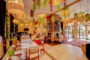 ein Restaurant mit Tischen, Stühlen und Kronleuchtern in der Unterkunft Taj Atlas Wellness Boutique Hôtel & Spa in Amizmiz