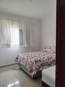a bedroom with a bed and a window at Casa Balneário Arpoador in Peruíbe