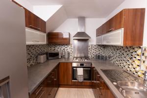 a kitchen with wooden cabinets and stainless steel appliances at Sweet Dreams in Peterborough
