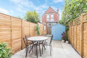 a patio with a table and chairs and a fence at 114 North Street in St. Andrews