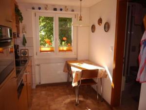 een kleine keuken met een tafel en een raam bij Birkli 2, 2 Bett Wohnung in Wengen