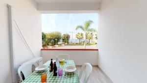 comedor con mesa, sillas y ventana en Große Wohnung in Balestrate mit Grill, Terrasse und Garten, en Balestrate