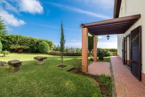 um jardim com bancos e um edifício de tijolos em Quinta D. Maria & Inês em Vila Franca do Campo