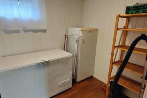uma cozinha com um frigorífico branco e uma prateleira em Apartment Solbakken Feriehus em Fevåg
