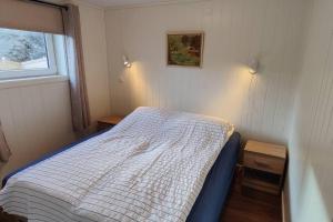 um pequeno quarto com uma cama e uma janela em Apartment Solbakken Feriehus em Fevåg