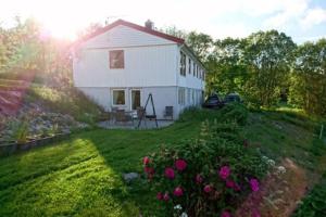 una casa blanca con un patio con flores en Apartment Solbakken Feriehus, en Fevåg