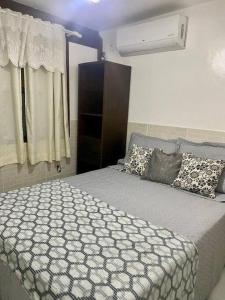 ein Schlafzimmer mit einem großen Bett und einem Fenster in der Unterkunft Paraíso no Sudoeste in São Pedro da Aldeia
