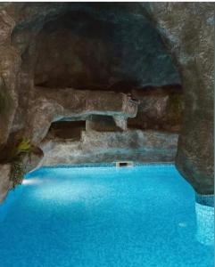 a swimming pool in a cave with blue water at Valentina Castle in Ognyanovo