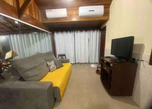 ein Wohnzimmer mit einem Sofa und einem Flachbild-TV in der Unterkunft Paraíso no Sudoeste in São Pedro da Aldeia