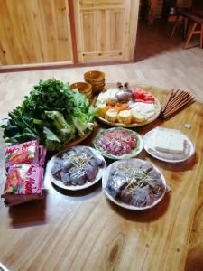a table with plates of food and vegetables on it at Phố Bảng Homestay in Pho Bang