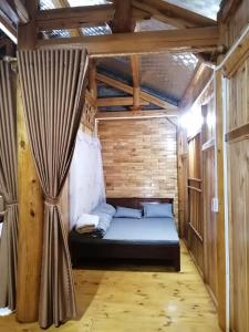 a bed in a room with a curtain at Phố Bảng Homestay in Pho Bang