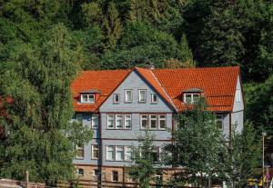 a large house with an orange roof at Gemütliche Ferienwohnung in Lerbach mit Garten, Grill und Terrasse in Lerbach