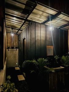une chambre sombre avec des plantes et des lumières sur le mur dans l'établissement Likod Bahay Cabin, 