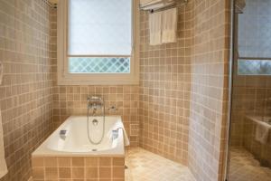 ein Badezimmer mit Badewanne und Waschbecken in der Unterkunft Hôtel La Pérouse Nice Baie des Anges in Nizza