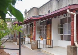 um edifício antigo com um alpendre e uma porta em VIJIJI HOTEL & CONFERENCE em Eldoret