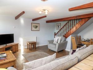 a living room with a couch and a tv at Dairy Cottage in South Molton