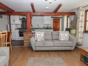 a living room with a couch and a kitchen at Dairy Cottage in South Molton