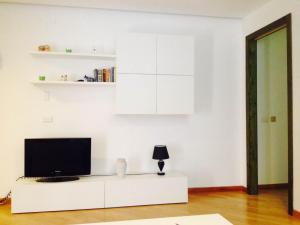 a living room with a tv on a white cabinet at Dimora Degli Oleandri in Matera